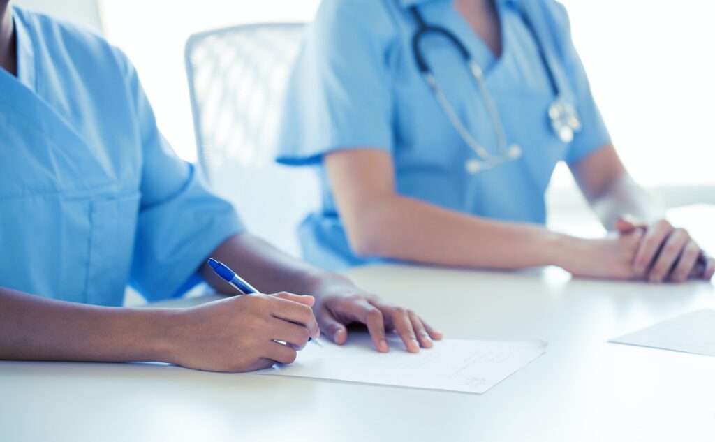 close up of doctor taking notes at hospital